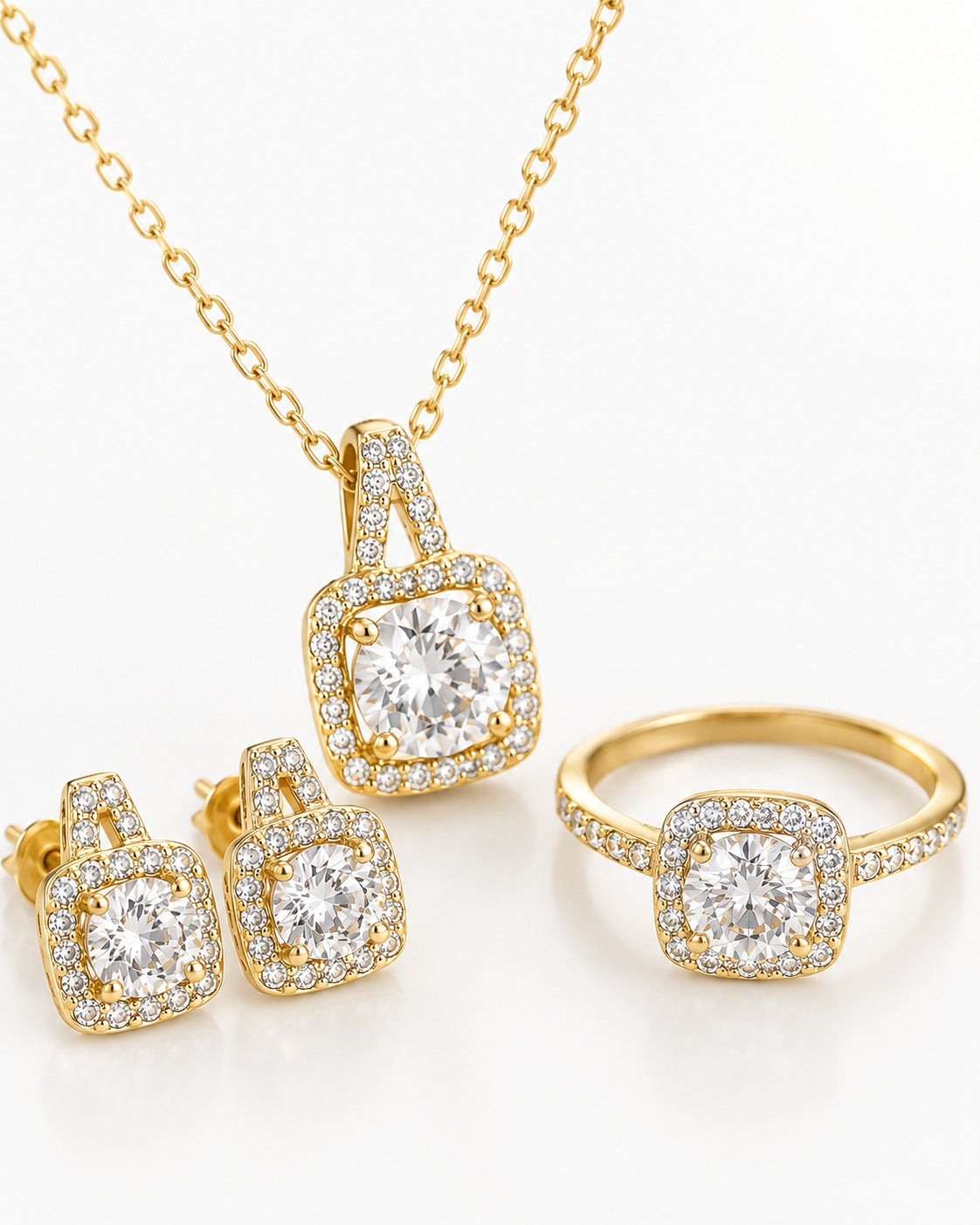 Gold jewelry set featuring a pendant necklace, matching stud earrings, and a ring, each with a square halo design set with clear gemstones on a white background.