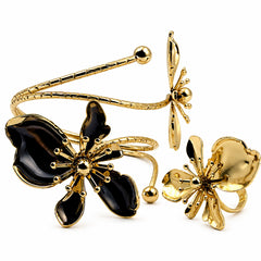 Gold-tone metal jewelry set featuring a butterfly cuff bracelet, a dragonfly pendant, and a matching butterfly ring, all decorated with glossy black enamel on a white background.