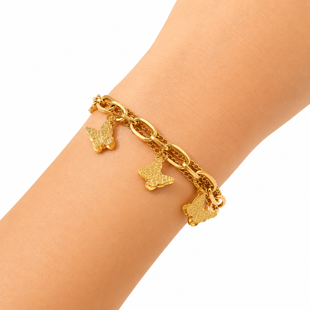 A gold chain bracelet with three textured butterfly charms, shown worn on a person's wrist against a plain white background.