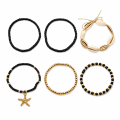 Six stretch bracelets arranged on a white background: two black beaded bracelets, one cream shell bracelet, one black and gold beaded bracelet with a starfish charm, one gold beaded bracelet, and one black and gold beaded bracelet.
