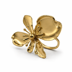 A gold flower-shaped ring with five petals and a central stamen cluster, photographed on a clean white background.